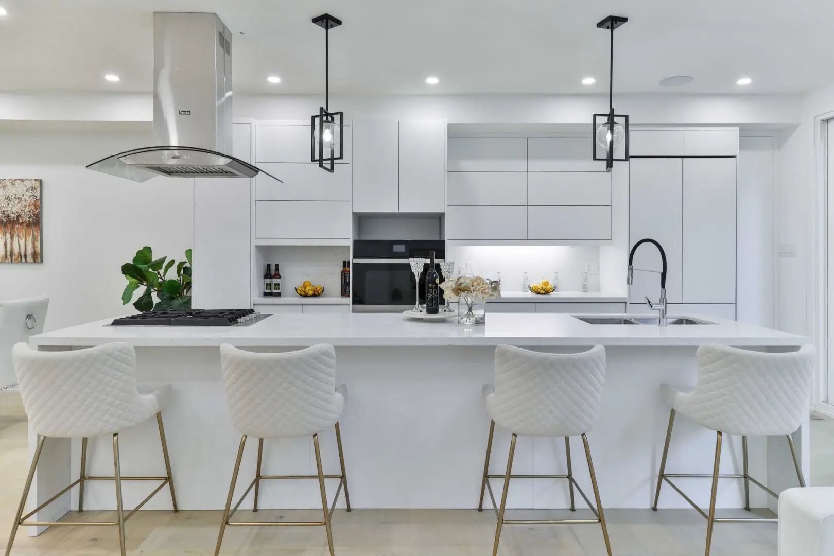 A kitchen with white cabinets and black appliances.